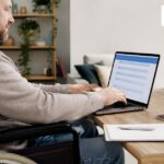 Wheelchair user completing an accessible online visa application at home