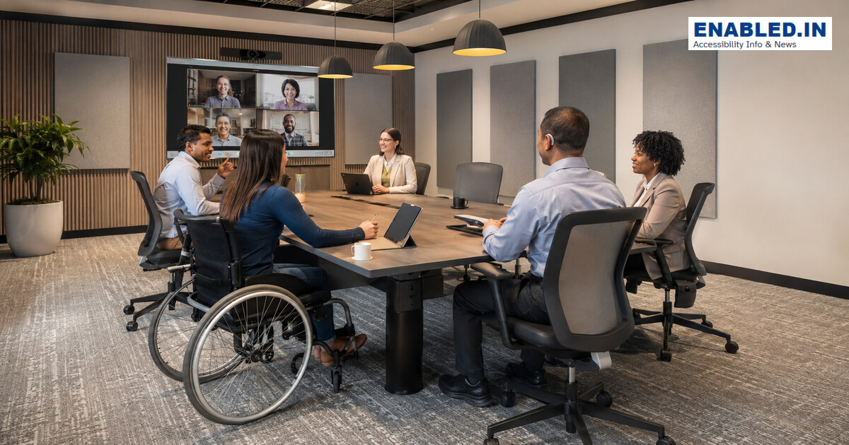 Inclusive meeting with a wheelchair user integrated around the table and hybrid participants on screen.
